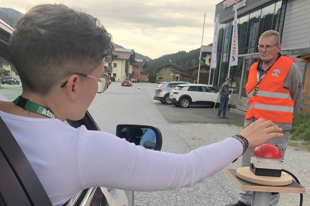 Beifahrerin lehnt sich aus dem Seitenfenster und drückt den Buzzer