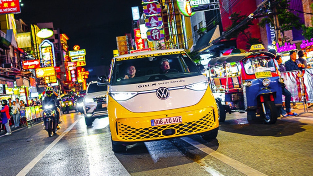 VW ID.Buzz bei der Weltumrundung auf einer nächtlichen Straße in einer thailändischen Großstadt.