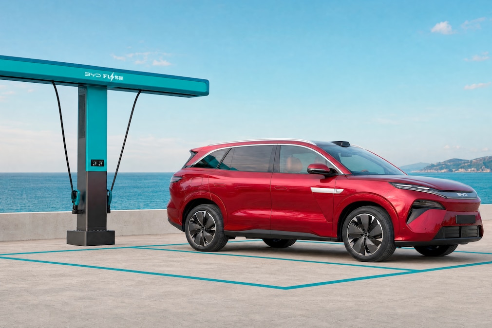 BYD Atto 8 geparkt an einer Flash-Charger-Ladesäule am Meer.