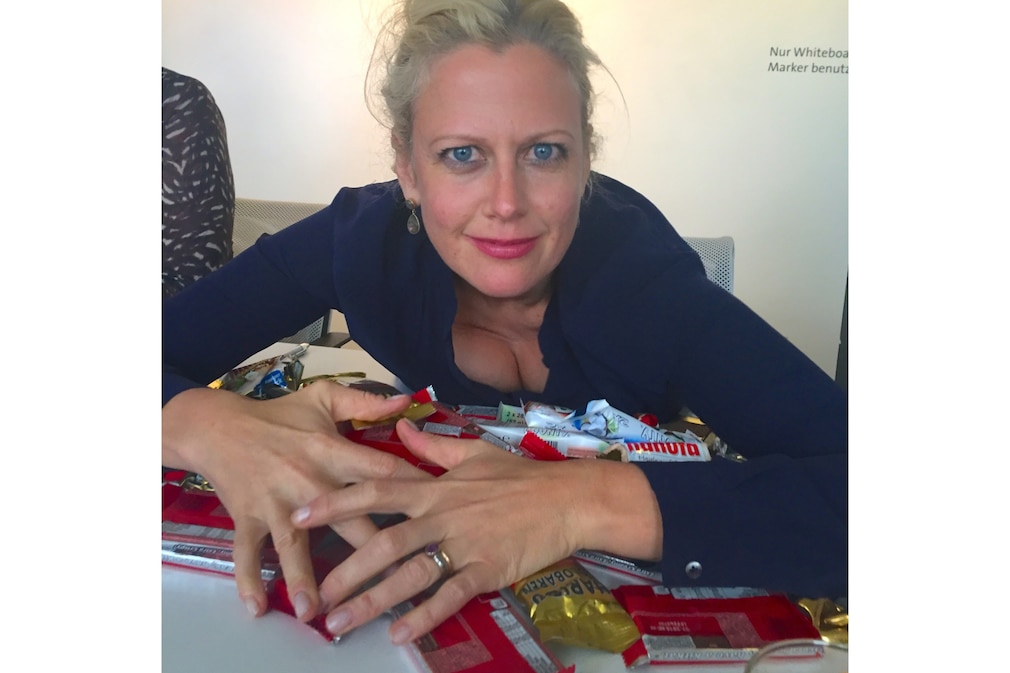 Barbara Schöneberger legt ihre Hände auf einen Berg Süßigkeiten