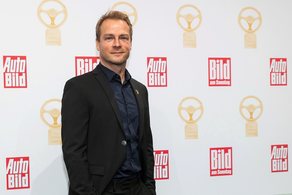 Hinnerk Schönemann allein an der Foto-Wand des Goldenen Lenkrads