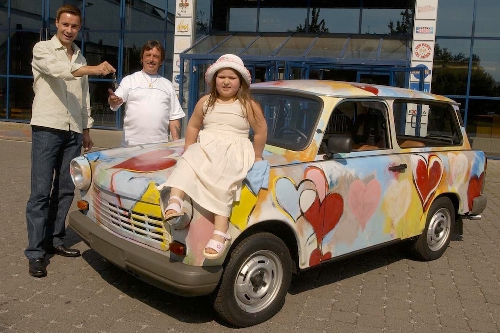 Im Mai 2002 übergibt Kai Pflaume den Kunst-Trabi an den Meistbietenden, Leo Keldenich (50) aus Aachen. Tochter Michelle (6) nimmt gleich Platz.