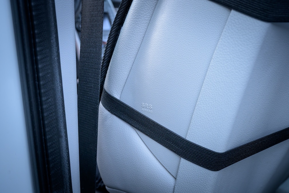 Detailaufnahme eines Autositzes bei dem die Haltegurte einer Heizmatte im Airbagbereich liegen