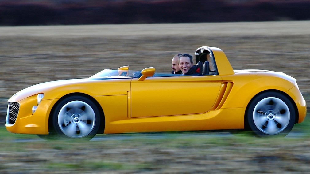 VW EcoRacer von der Seite, mit kleinem Windabweiser statt Windschutzscheibe. Redakteur Jan Horn lacht in die Kamera