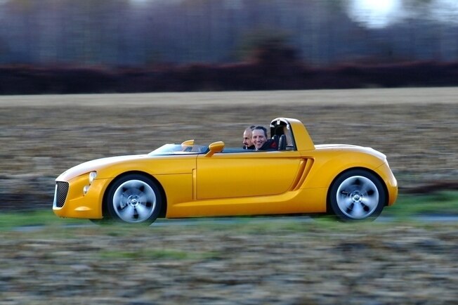 VW EcoRacer von der Seite, mit kleinem Windabweiser statt Windschutzscheibe. Redakteur Jan Horn lacht in die Kamera