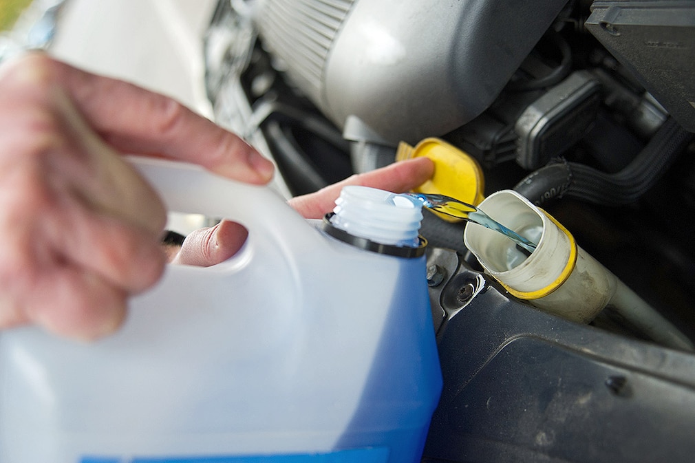 Ein Mann fuellt am 05.11.2014 in Berlin Frostschutzmischung in den Vorratstank der Scheibenwaschanlage seines Autos.