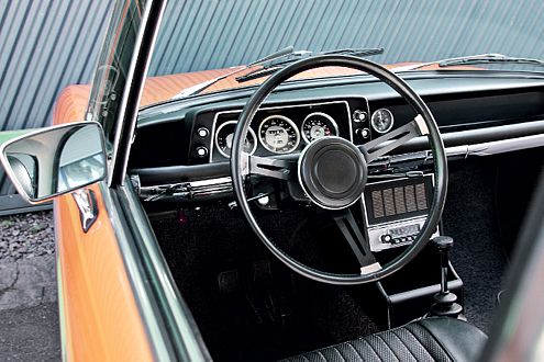 Sportlook 1968: schwarzes Interieur, dünnes Speichenlenkrad, drei große Rundinstrumente und ein griffiger Schaltknauf.