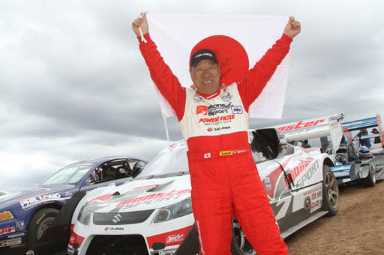 Pikes--Peak-Sieger Tajima hält die Japan-Flagge hinter sich hoch