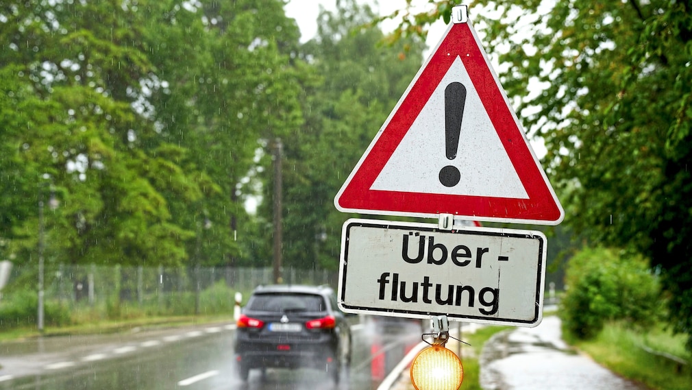 Warnschild: berflutung, an einer Stra§e Stra§e zwischen Gersthofen und Augsburg. Symbolbild Dauerregen und Dammbruch im Landkreis Augsburg