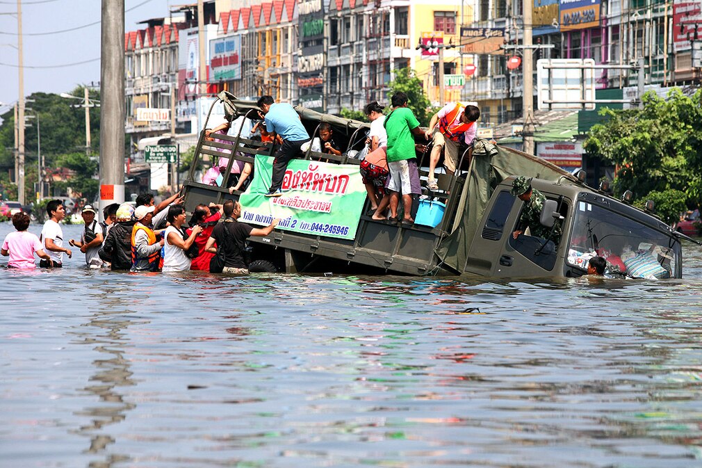 An Army truck carrying evacuees sinks into flood water after driving into a drain in Bangkok