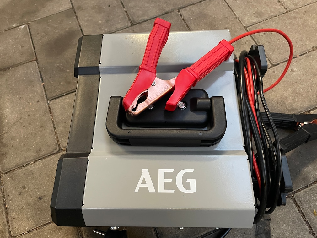 Produktfoto: Das AEG Ladegerät zeigt die lose Isolierung an einer Polklemme.