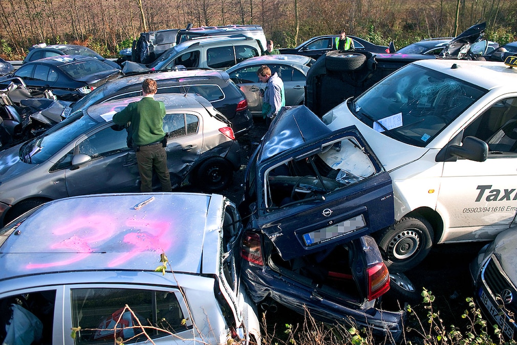 Ermittler der Polizei untersuchen am Samstag (19.11.2011) auf der Autobahn A31 bei Heek Autos die nach einer Massenkarambolage verkeilt ineinander stehen