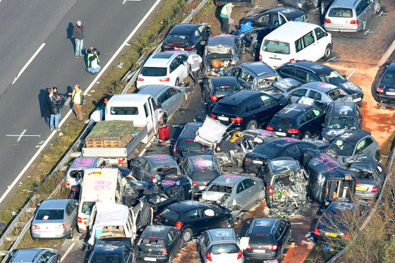 Ermittler der Polizei untersuchen am Samstag (19.11.2011) auf der Autobahn A31 bei Heek Autos die nach einer Massenkarambolage verkeilt ineinander stehen 