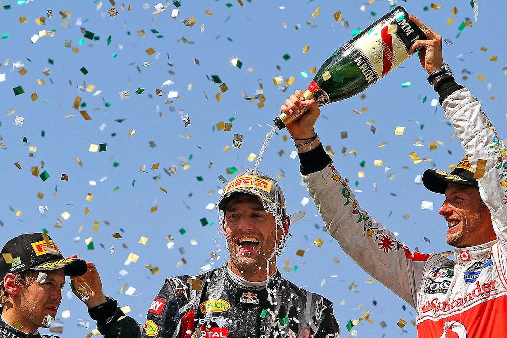 Australian Formula One driver Mark Webber (C) of Red Bull Racing celebrates with his second placed German teammate Sebastian Vettel (L) and third placed British Jenson Button (R) of McLaren Mercedes